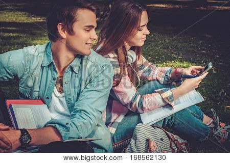 Cheerful couple with studying in green park