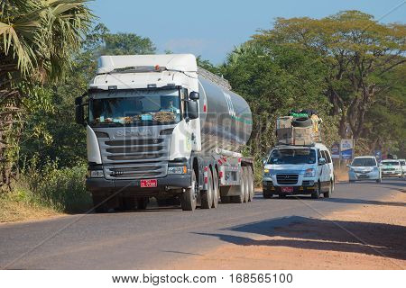 KAYIN STATE, MYANMAR - DECEMBER 28, 2016: Minivan overtaking a tanker truck. Traffic on the highway Bago - Myawaddy