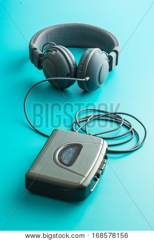 The vintage audio player and headphones on blue background.