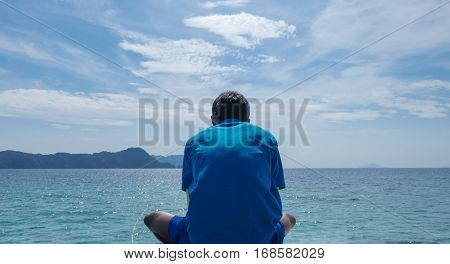 A man sitting lonely looking at horizon