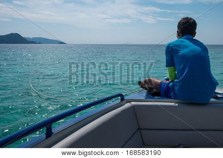 A seaman sitting lonely on boat looking at horizon