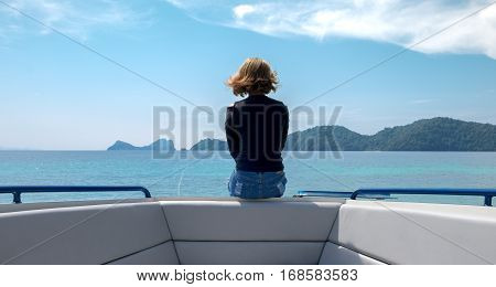 A woman sitting lonely on boat looking at the horizon