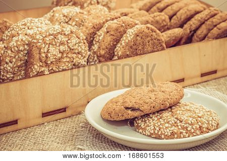 Biscuits with sesame seeds on a plate and a tray