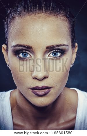 Brunette girl with beautiful make-up and wet in a spray of water close-up