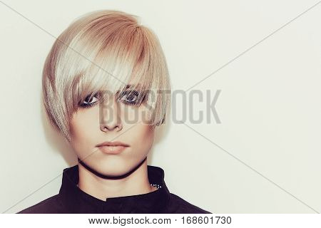 Woman with stylish short hairstyle on a light background