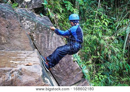 Beaufort,Sabah,Malaysia-Jan 28,2017:Adventure man rappelling Jempangah waterfall in Beaufort,Sabah,Borneo.Waterfall Abseiling activity adventure getting famous in Sabah,Borneo,Malaysia