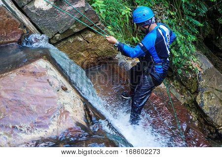 Beaufort,Sabah,Malaysia-Jan 28,2017:Adventure man rappelling Jempangah waterfall in Beaufort,Sabah,Borneo.Waterfall Abseiling activity adventure getting famous in Sabah,Borneo,Malaysia