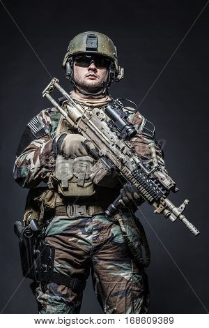 United states Marine Corps special operations command Marsoc raider with weapon. Studio shot of Marine Special Operator half-turning black background
