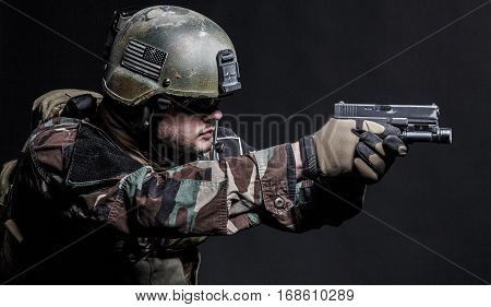United states Marine Corps special operations command Marsoc raider with pistol. Studio shot of Marine Special Operator black background