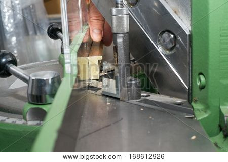 Craftsman working on frame in frameshop. Professional framer hand holding frame angle. Top view.