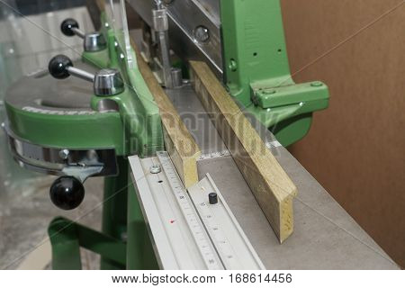 Craftsman working on frame in frameshop. Professional framer hand holding frame angle. Top view.