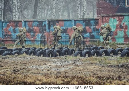 Ukrainian soldiers run with duffel bags during military training