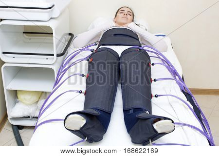Woman at the clinic for the treatment of pressure therapy procedure