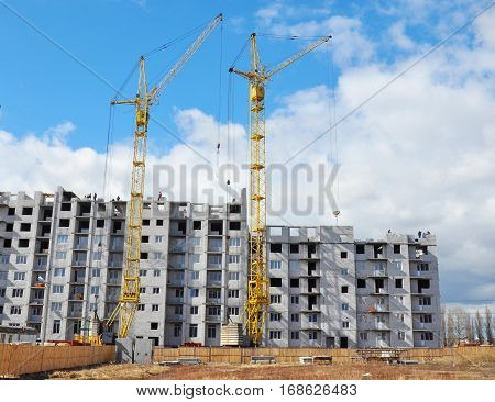 Two Building Cranes and Building High Rise with Copy Space. Building Development with Cranes Construction.