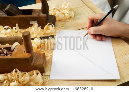 White sheet on wooden table for carpenter tools with sawdust. Copy space. Top view.