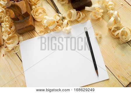 White sheet on wooden table for carpenter tools with sawdust. Copy space. Top view.