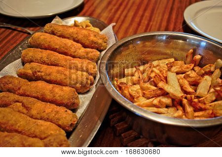 Stuffed Karadjordje schnitzel and french fries on a wooden table