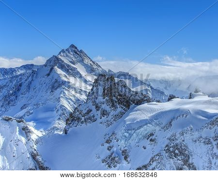 Alps, view from the top of Mt. Titlis in Switzerland in winter. Titlis is a mountain of the Uri Alps, located on the border between the Swiss cantons of Obwalden and Bern.