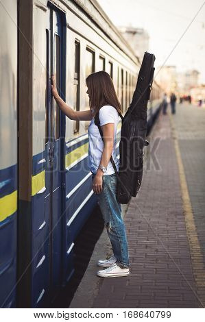 Woman With Guitar At The Railway Station