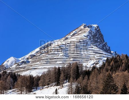Summit of Schiahorn mountain with snow fences for avalanche control, as seen from the town of Davos in the Swiss canton of Graubunden in wintertime.