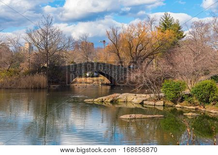 New York City USA February 2 2017 -- The Gapstow Bridge in Central Park with ducks swiming in the pond below it.