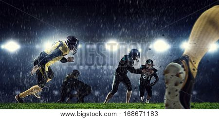 American football players at arena . Mixed media