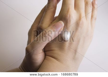 Hands of caucasian woman selfmassage with cream