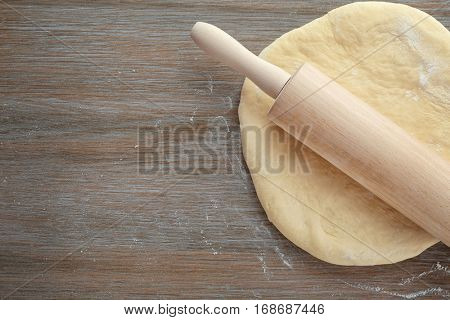 Roller pin and dough on wooden table