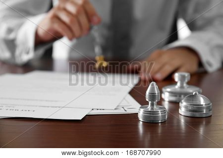 Metal stamps, papers and ink pad on notary public table