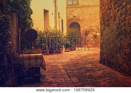Empty street of small Tuscany town San Quirico d'Orcia in the morning fog, romantic travel vintage hipster european italy background