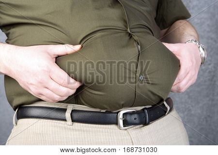 Mid-adult man with hands on belly, mid section