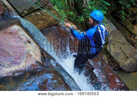 Beaufort,Sabah,Malaysia-Jan 28,2017:Adventure man rappelling Jempangah waterfall in Beaufort,Sabah,Borneo.Waterfall Abseiling activity adventure getting famous in Sabah,Borneo,Malaysia