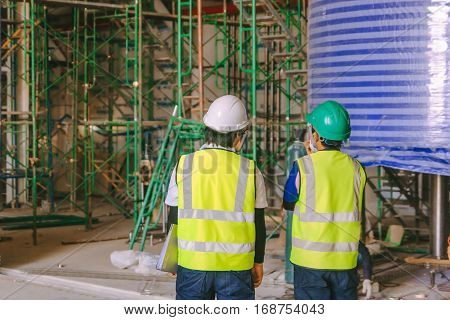Engineer group and worker meeting discussion with team on Construction site work