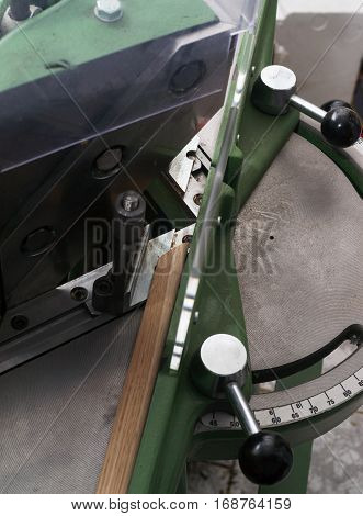 Craftsman working on frame in frameshop. Professional framer hand holding frame angle. Top view.