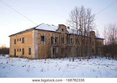The thrown two-storeyed house in the January evening. The working settlement Russian America of the enterprise for extraction of peat in the Leningrad region. Russia
