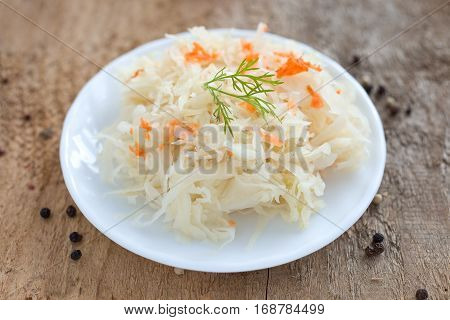 Ferment cabbage with carrot on a white plate.