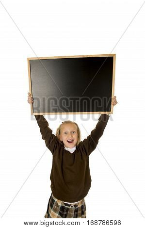 7 or 8 years old little beautiful blond schoolgirl smiling happy and cheerful holding and showing small blank blackboard with copy space in child school education concept isolated on white background