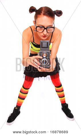 Fotografo di giovane donna con fotocamera su uno sfondo bianco.