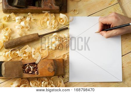 White sheet on wooden table for carpenter tools with sawdust. Copy space. Top view.