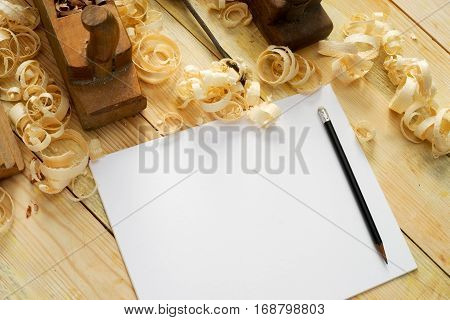 White sheet on wooden table for carpenter tools with sawdust. Copy space. Top view.