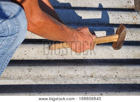 How to pull out the nails correctly from asbestos old roof tiles. Roof worker repair dangerous asbestos old roof tiles. Roofing construction.