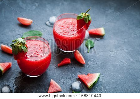 Summer cocktail with watermelon and strawberry on stone background