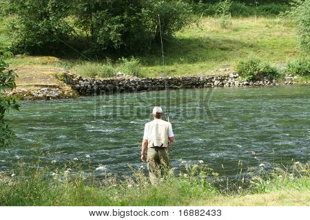 in piedi l'uomo pescatore di fiume con bastone di pesca