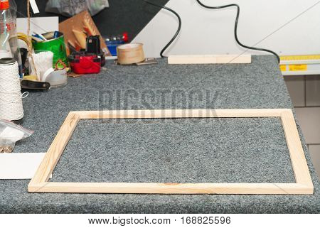 Craftsman working on frame in frame shop. Professional framer hand holding frame angle. Top view.
