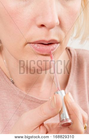 Pink Gloss Applied On A Woman's Lips