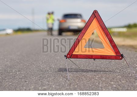 road sign, emergency and traffic concept - warning triangle over broken car 