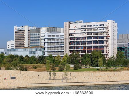 Basel, Switzerland - 27 August, 2016: embankment of the Rhine river and buildings of Novartis. Novartis International AG is a Swiss pharmaceutical company based in Basel, ranking number one in sales in the pharmaceutical industry worldwide.
