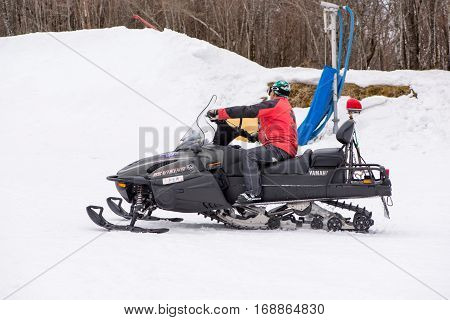 February 4 2017. Close-up of a paramedic riding on a snowmobile to the site of a snowboarding accident. Gokase Ski Area Miyazaki Japan.