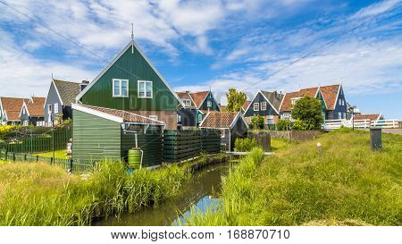 Traditional Dutch Fishing Village Scene With Wooden Houses And Canal