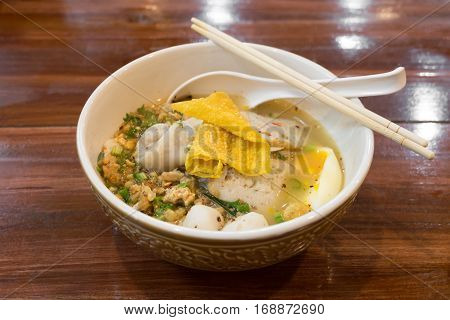 Thai spicy noodle soup on wooden table